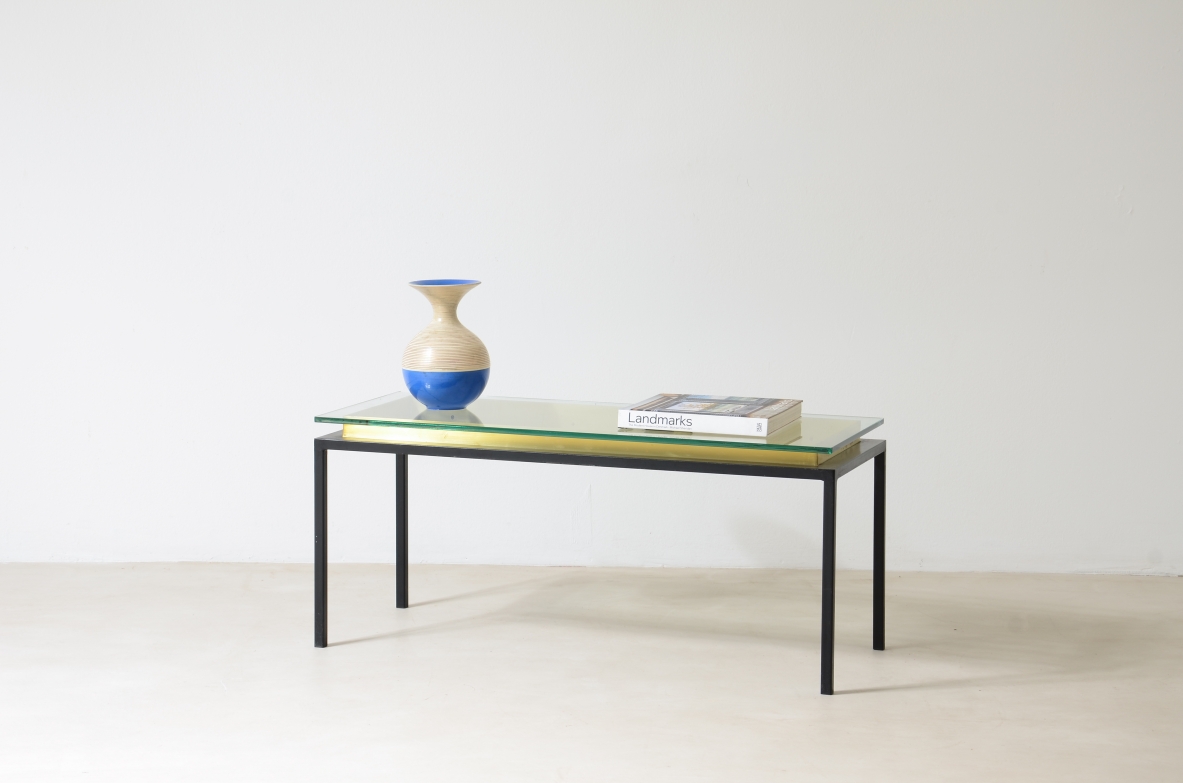 Low table tables with satin black metal structure, glass top resting on a brass frame.