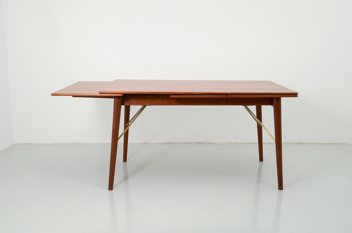 Peter Hvdt & Orla Molgaard Nielsen, large 1960's extensible dining table in teak wood with four brass arms holding the legs.