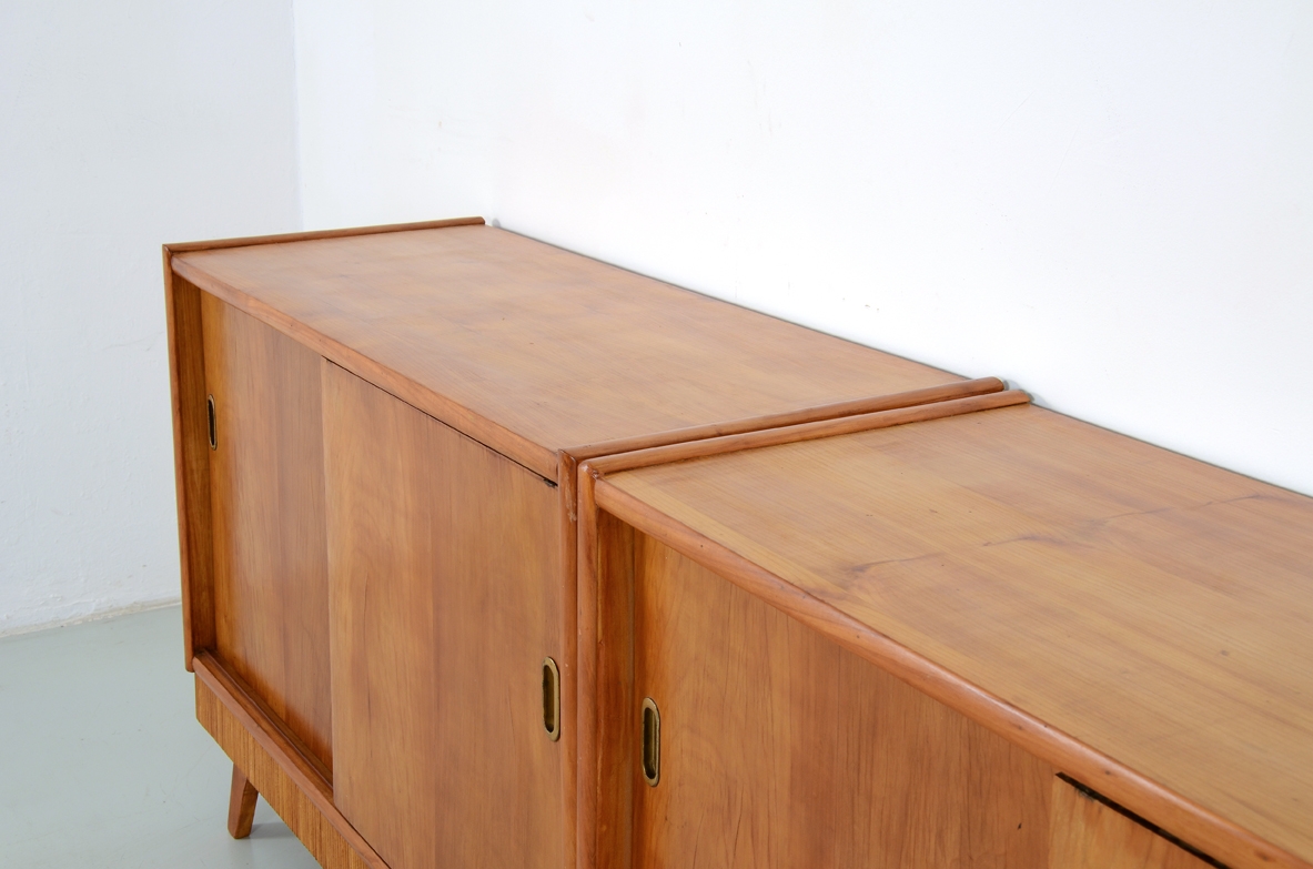 Coppia di credenze in ciliegio con ante scorrevoli e bella fascia in legno grissinato, Italia 1950.