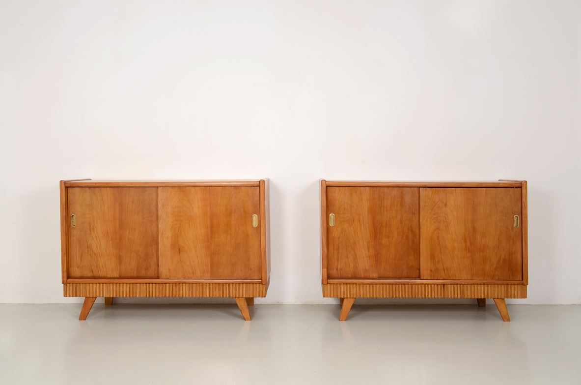 Coppia di credenzini in ciliegio con ante scorrevoli e bella fascia in legno grissinato, Italia 1950.