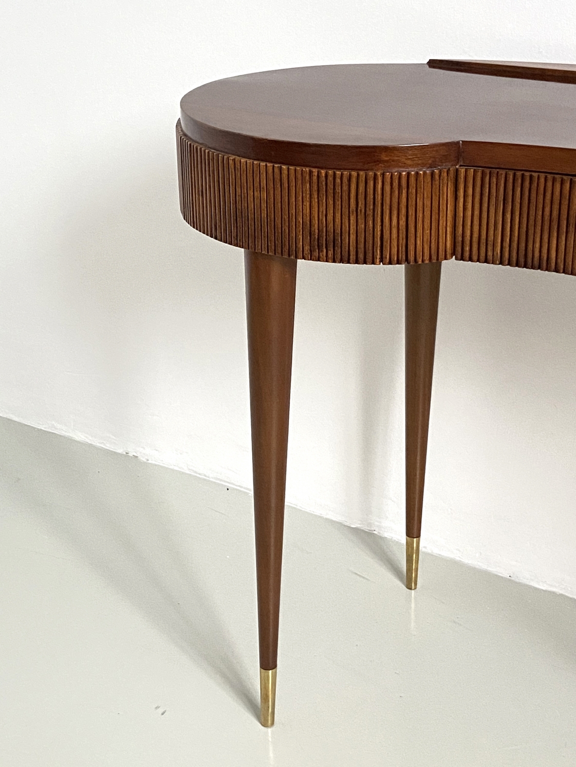 Elegant Italian 1950's console table with thin long legs and brass tips.