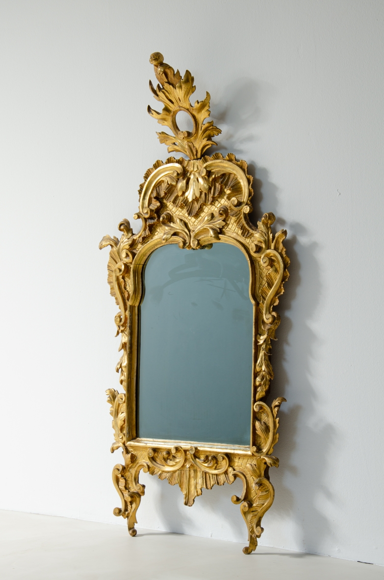 specchiera intagliata e dorata a foglia d'oro zecchino con specchio a Mercurio coevo. Italia 1750 circa