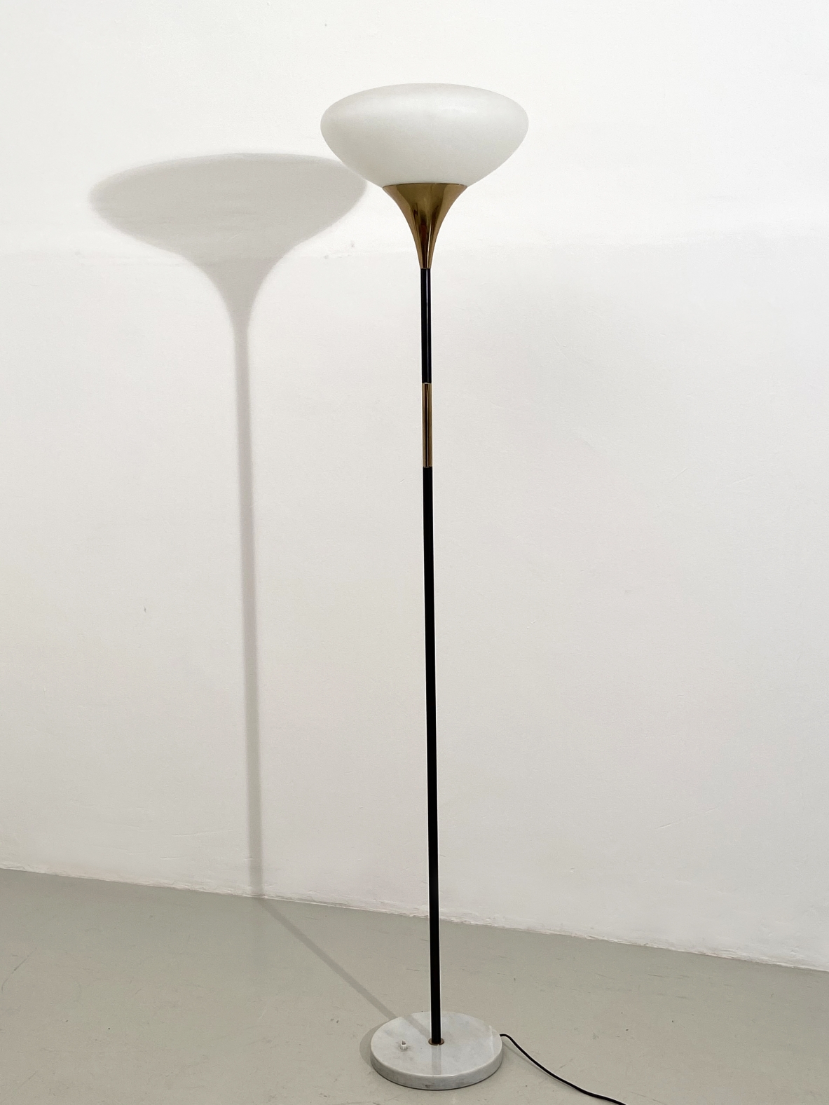 Stilnovo, piantana con base in marmo, stelo in metallo e ottone e vetro opaline di forma ellittica, 1960ca. Stilnovo, piantana con base in marmo, stelo in metallo e ottone e vetro opaline di forma ellittica, 1960ca.