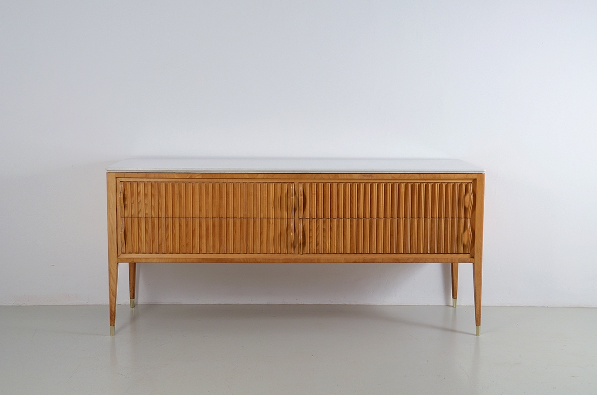 Comò in acero biondo con fronte grissinato a quattro cassetti e piano in marmo “Bianco Neve” a grana fine. Prod. Cassina, 1957.
