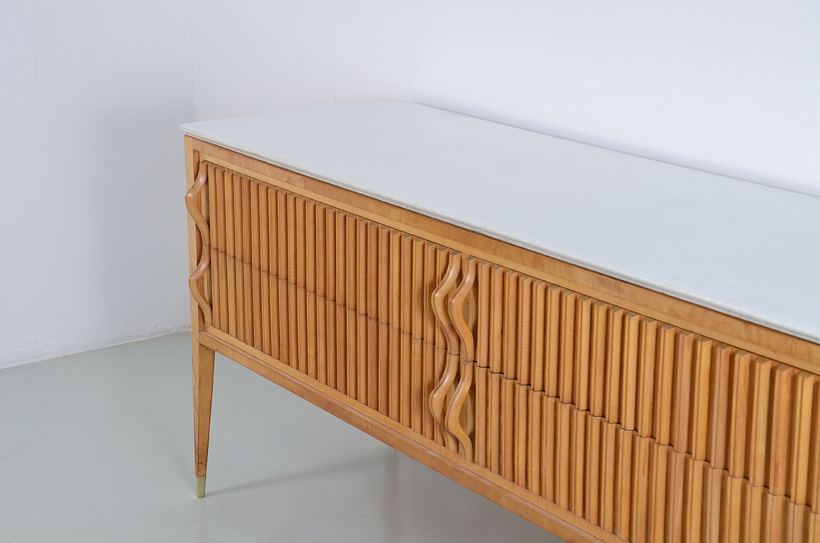 Comò in acero biondo con fronte grissinato a quattro cassetti e piano in marmo “Bianco Neve” a grana fine. Prod. Cassina, 1957.