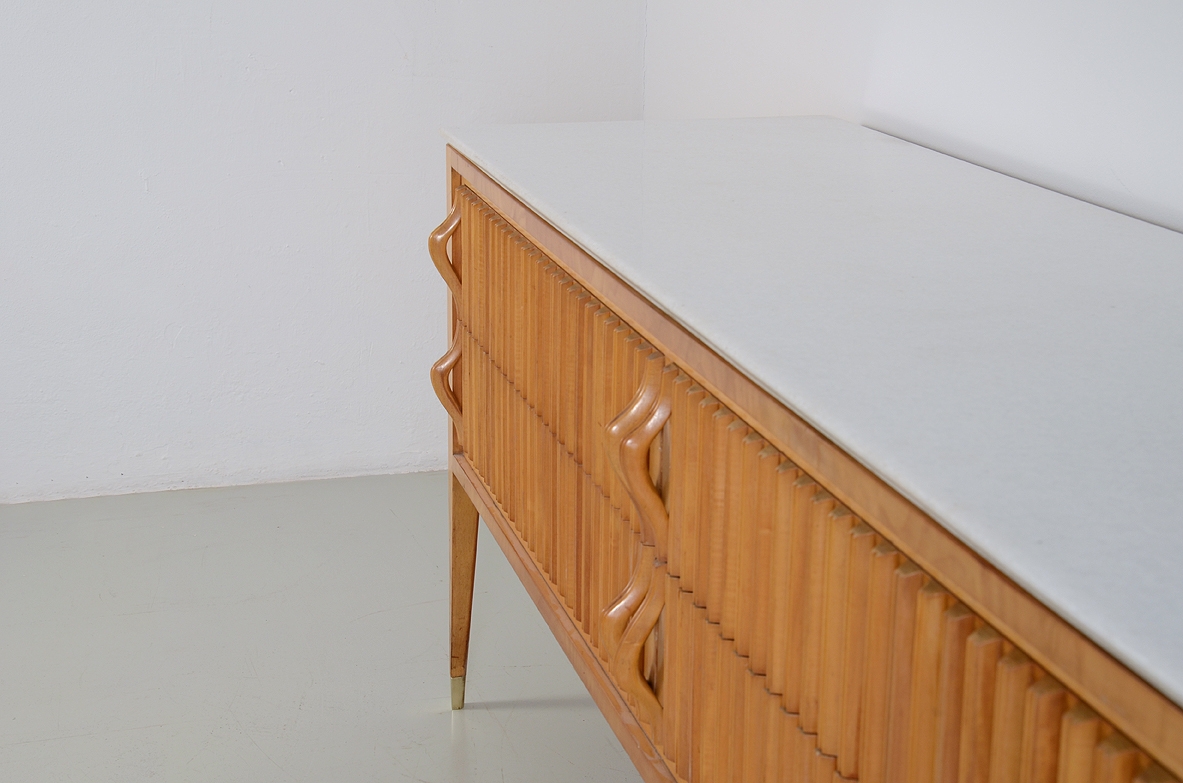 Comò in acero biondo con fronte grissinato a quattro cassetti e piano in marmo “Bianco Neve” a grana fine. Prod. Cassina, 1957.