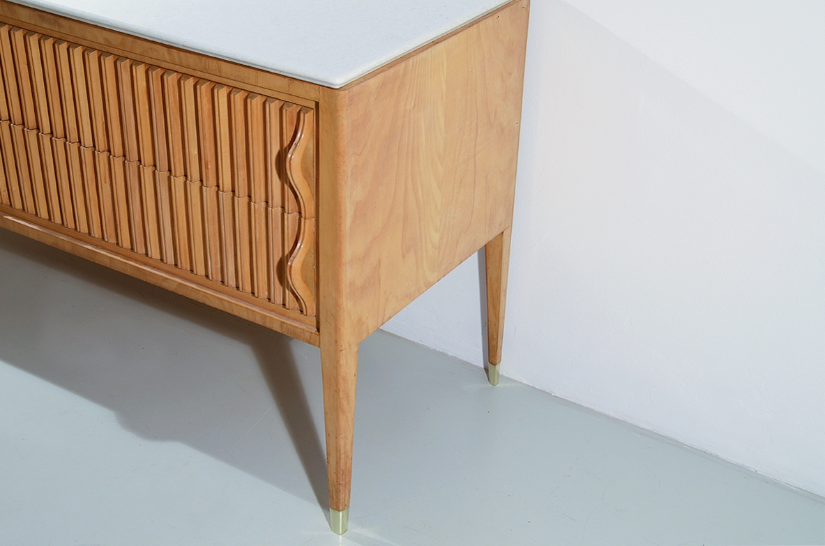 Comò in acero biondo con fronte grissinato a quattro cassetti e piano in marmo “Bianco Neve” a grana fine. Prod. Cassina, 1957.