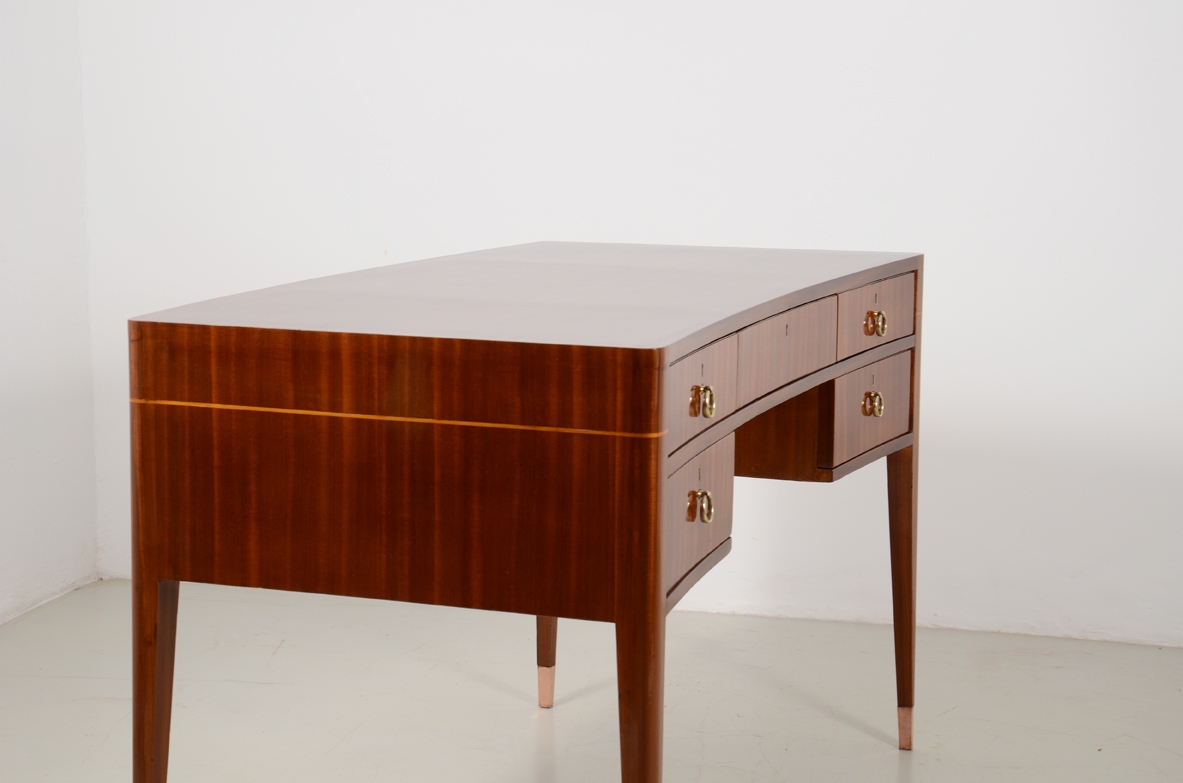 Italian elegant and curved 1950's desk in walnut and maplewood with five drawers and brass tips.