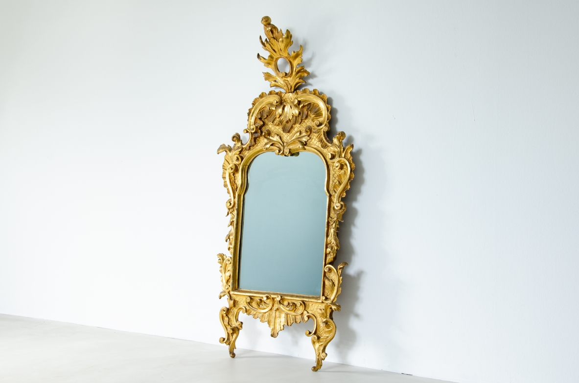 specchiera intagliata e dorata a foglia d'oro zecchino con specchio a Mercurio coevo. Italia 1750 circa