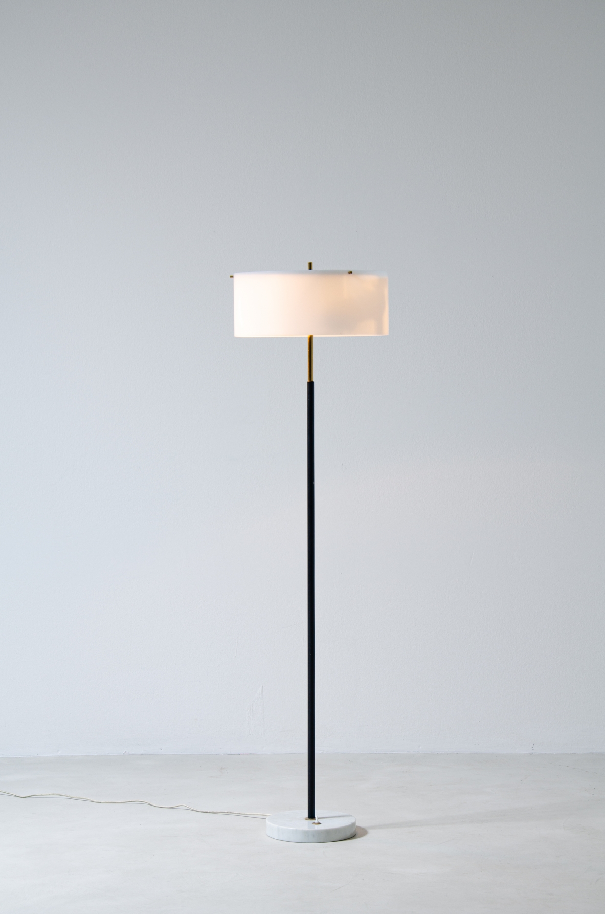 Tito Agnoli, metal and brass floor lamp with marble base and black and white methacrylate hat.  Produced by Oluce 1955.