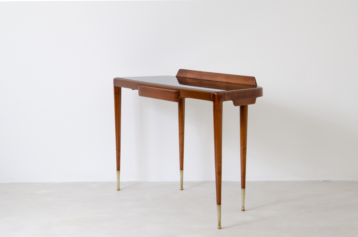 Elegant console table with thin legs in blond walnut and long brass tips. Central drawer and top in black opaline glass.  Italian manufacture, 1950s.