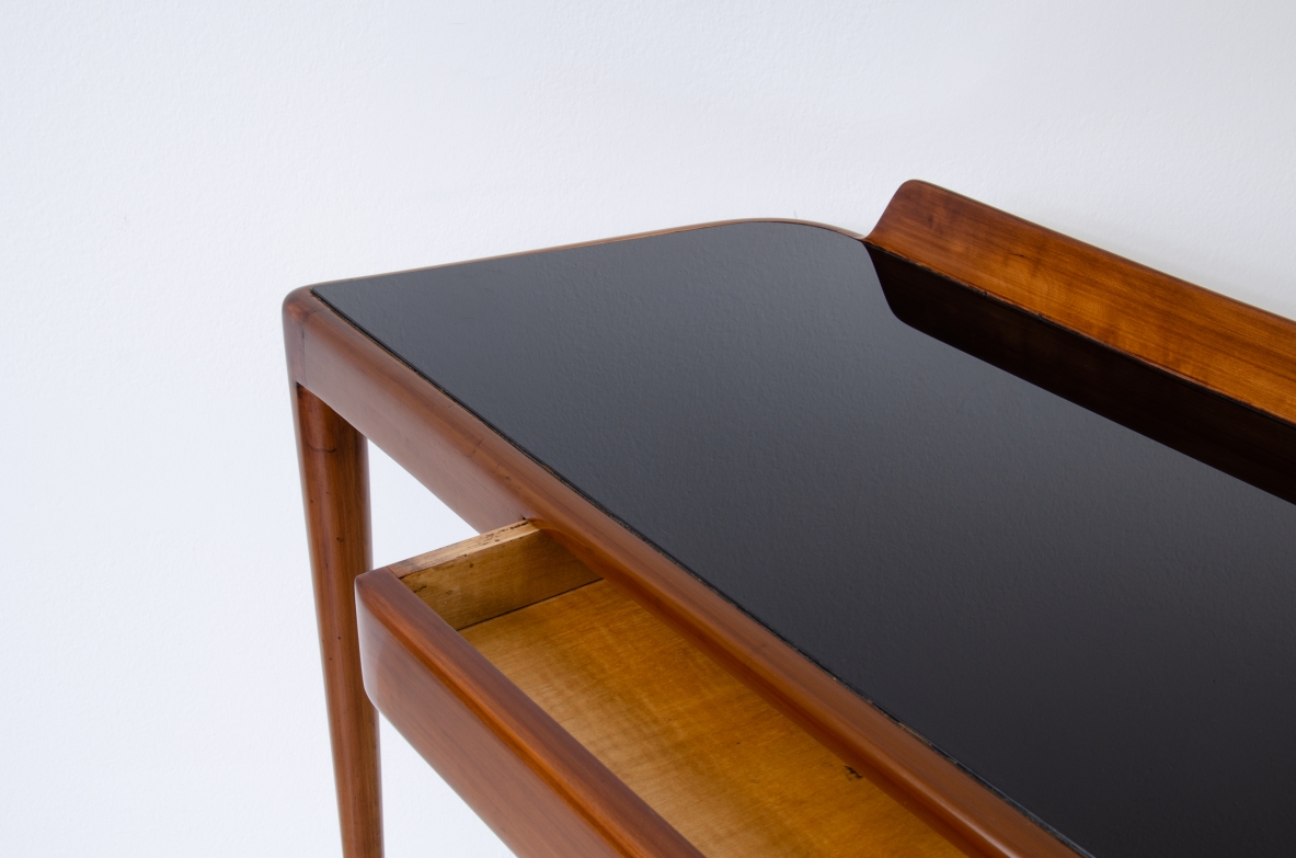 Elegant console table with thin legs in blond walnut and long brass tips. Central drawer and top in black opaline glass.  Italian manufacture, 1950s.