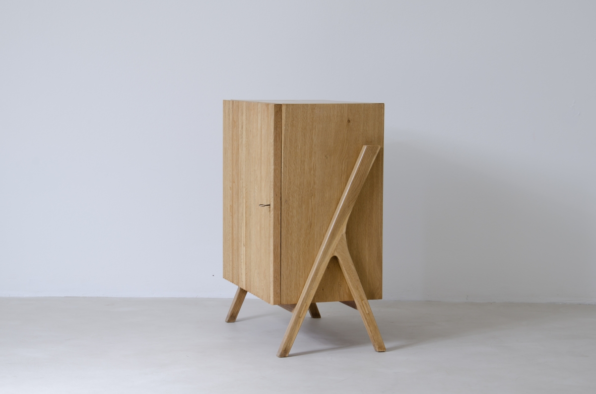 Piccolo mobile contenitore in rovere chiaro con fronte in legno cannettato.  Manifattura italiana anni 50'.