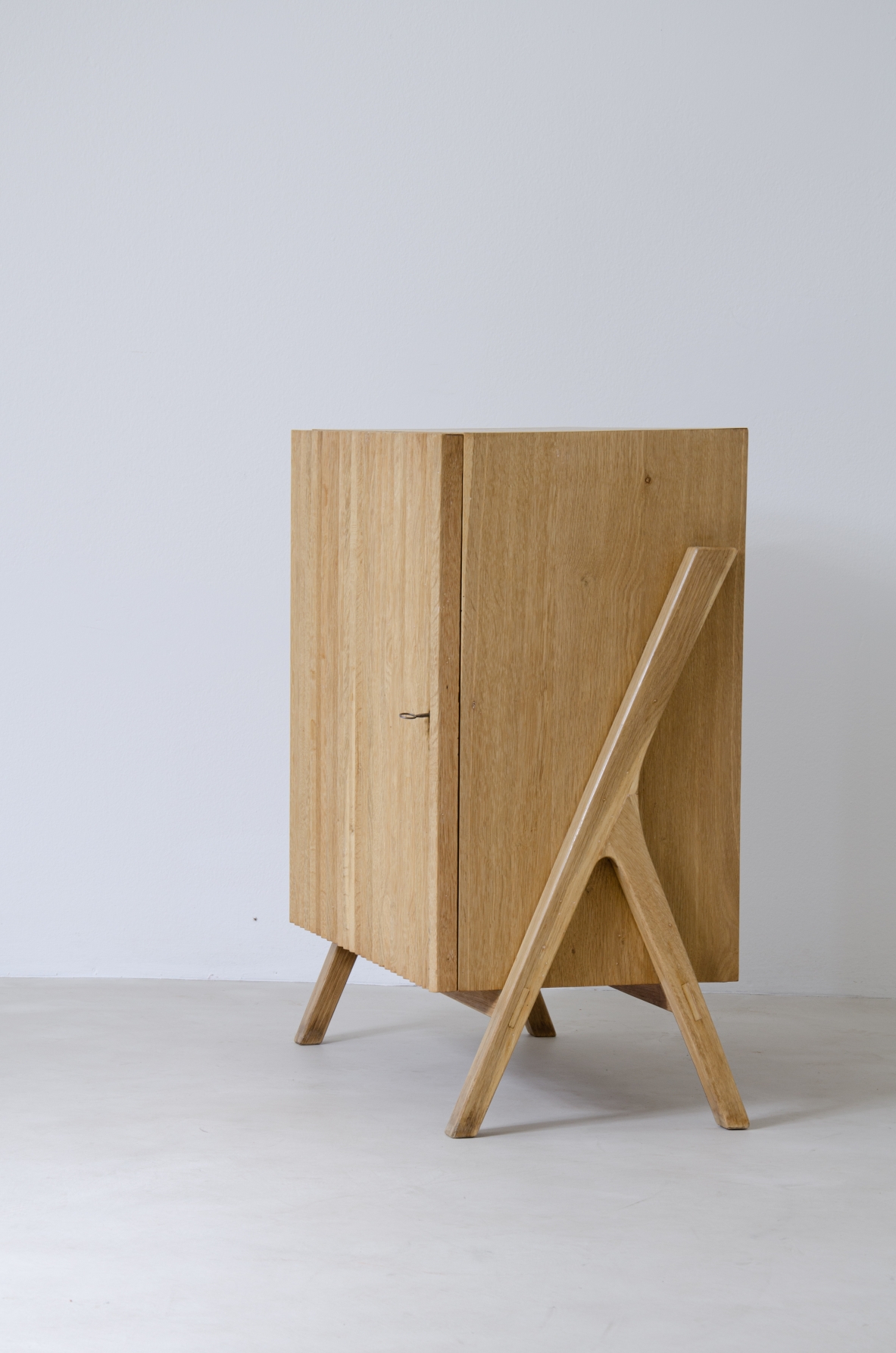 Piccolo mobile contenitore in rovere chiaro con fronte in legno cannettato.  Manifattura italiana anni 50'.