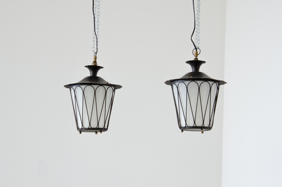 Pair of chandeliers with dark green metal structure and brass details. White glass curved inside.  Manifactured by Casa & Giardino, Milano, 1930s.