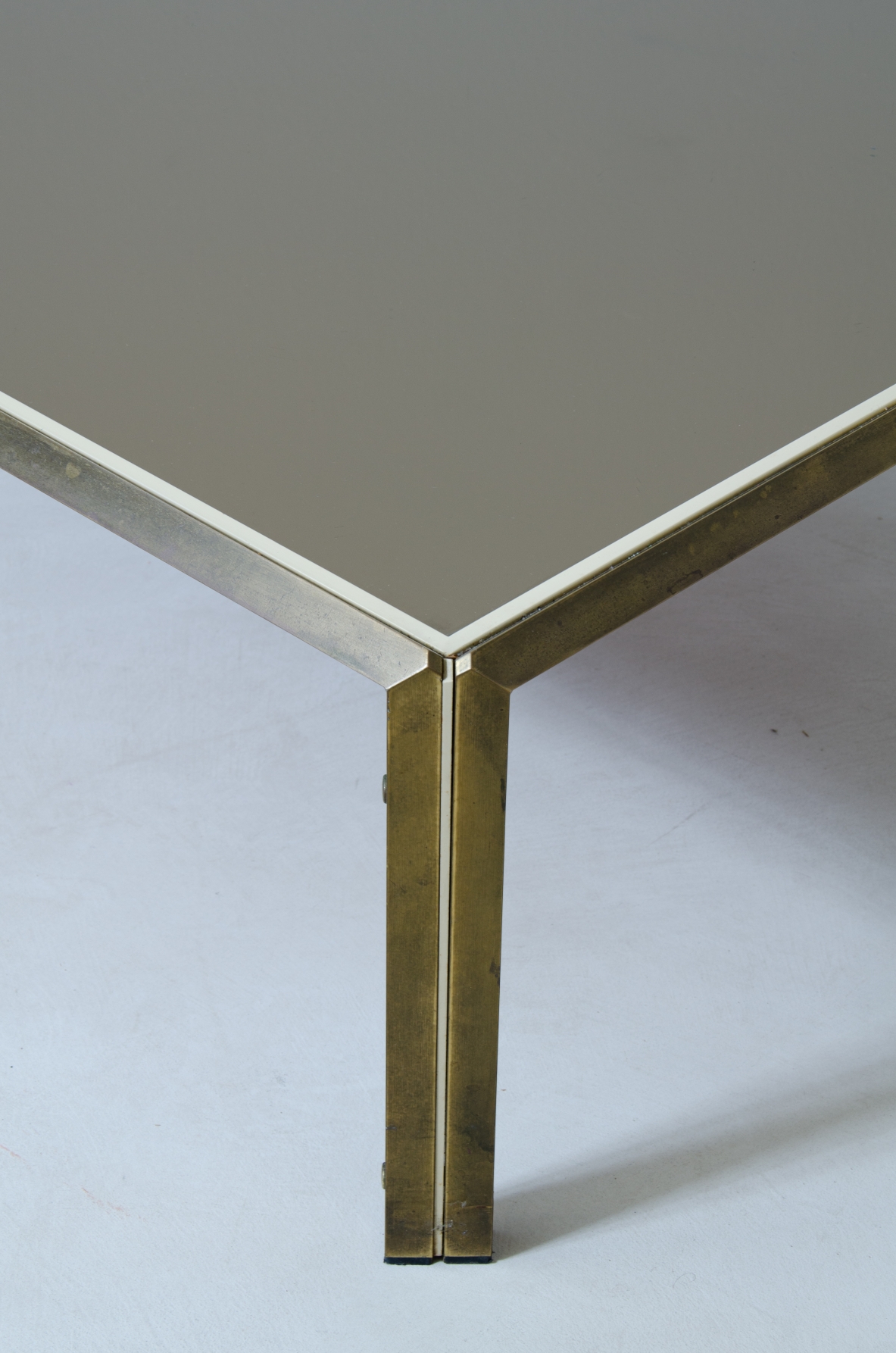 Willy Rizzo (1928-2013)  Tavolino in ottone e metallo verniciato con piano in vetro specchiato bronzo scuro.  Prodotto da Officine Willy Rizzo, Tivoli, 1970.