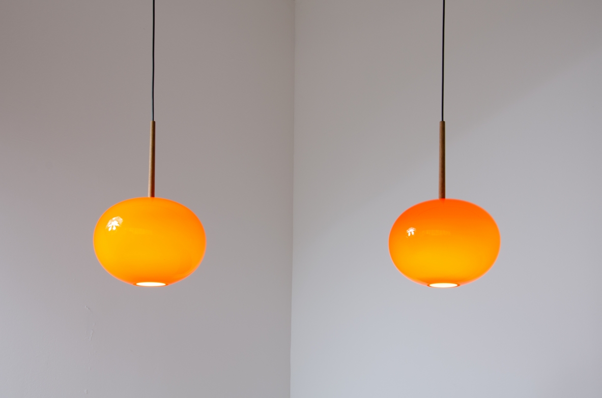 Pair of pendant chandeliers with wooden stem and red blown glass diffuser.  Scandinavia, 1950s.