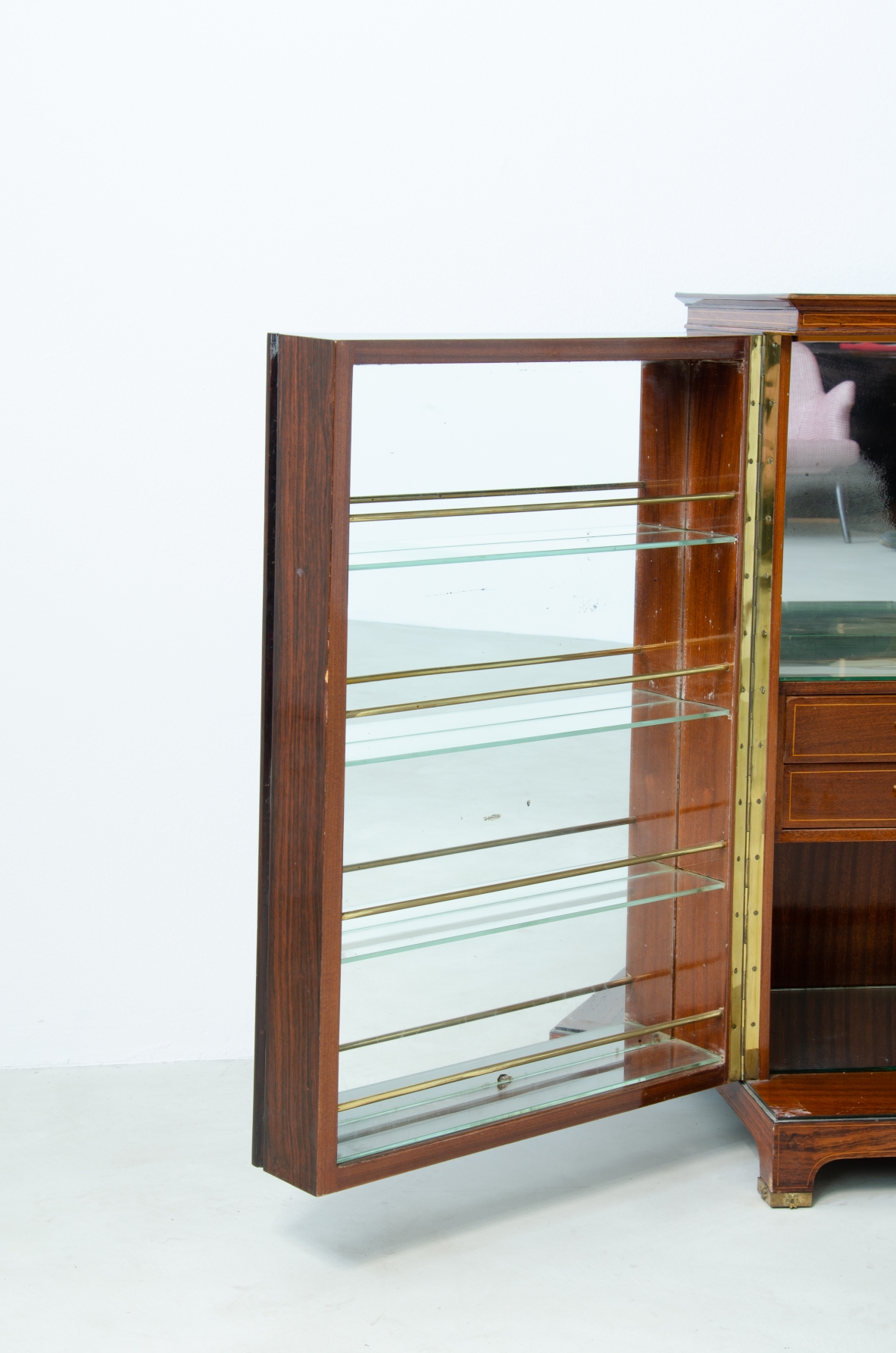 Paolo Buffa (1903-1970)  Elegant bar cabinet with inlaid rosewood and amber mirrors. Inside shelves and drawers with compartments and bottle racks covered in mirror. Brass details.  Italian manufacture, 1940s.