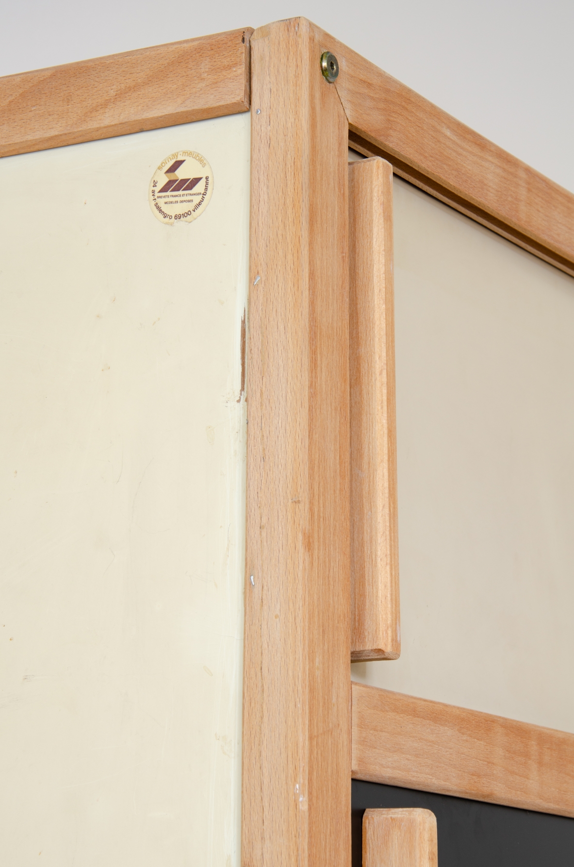 André Sornay (1902.2000)  Mobile con ante scorrevoli in legno laccato a due colori, struttura in legno e pannelli in multistrato laccato, base in ferro.  Francia, Lione, 1950ca.