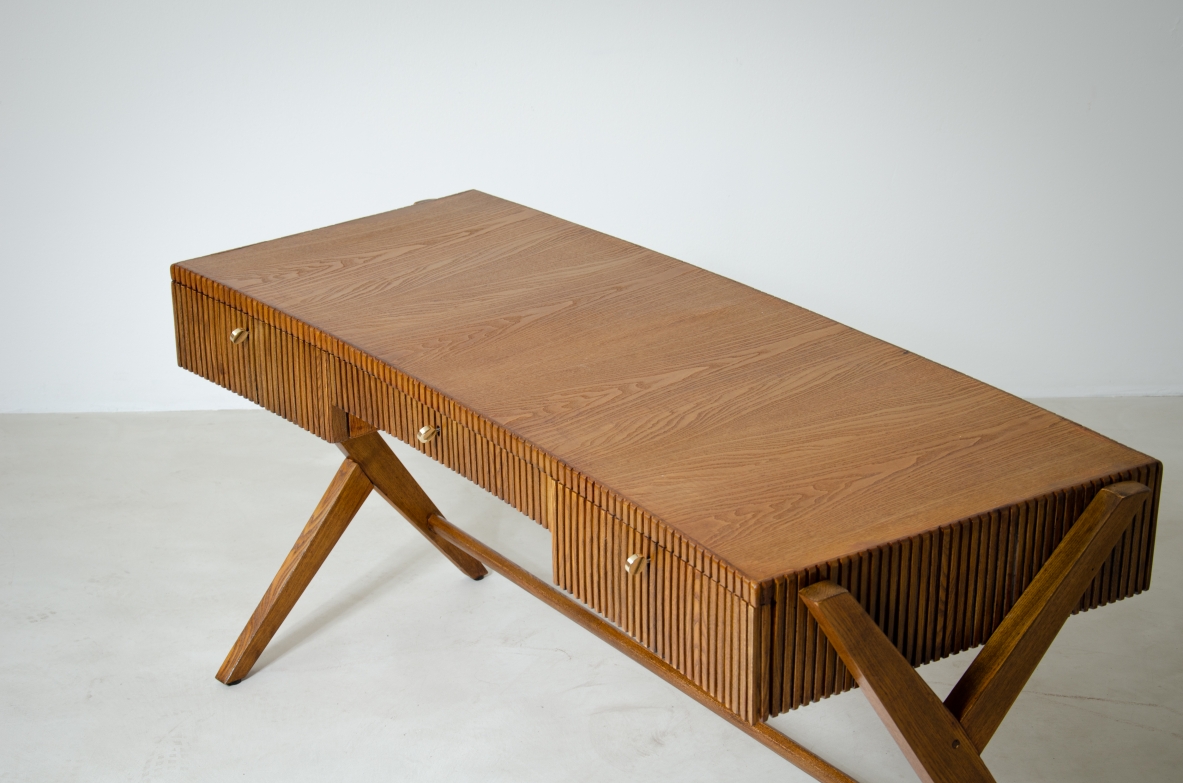 Scrivania in rovere a tre cassetti con fascia in legno cannettato e piano curvato sostenuto da gambe a doppia Y.  Scuola di Torino, 1950ca.
