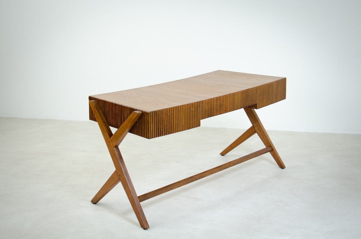 Scrivania in rovere a tre cassetti con fascia in legno cannettato e piano curvato sostenuto da gambe a doppia Y.  Scuola di Torino, 1950ca.