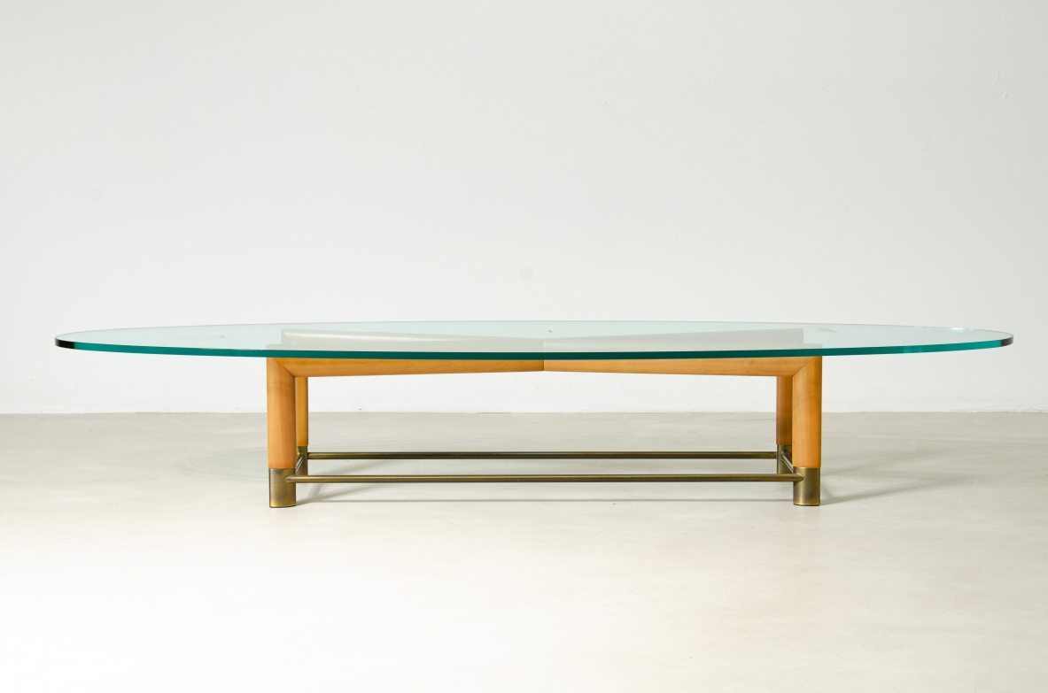 Tavolino ovale con struttura in legno, piedini in ottone e piano in cristallo molato. Manifattura italiana, 1950ca.