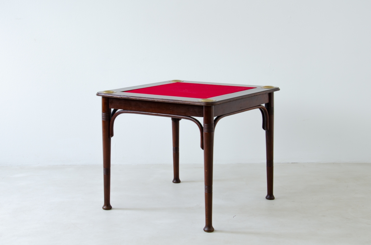 Tavolo in legno curvato e piano in panno rosso con dettagli in ottone. Produzione J.J.Kohn, Vienna, inizio XX sec. Tavolo in legno curvato e piano in panno rosso con dettagli in ottone. Produzione J.J.Kohn, Vienna, inizio XX sec.