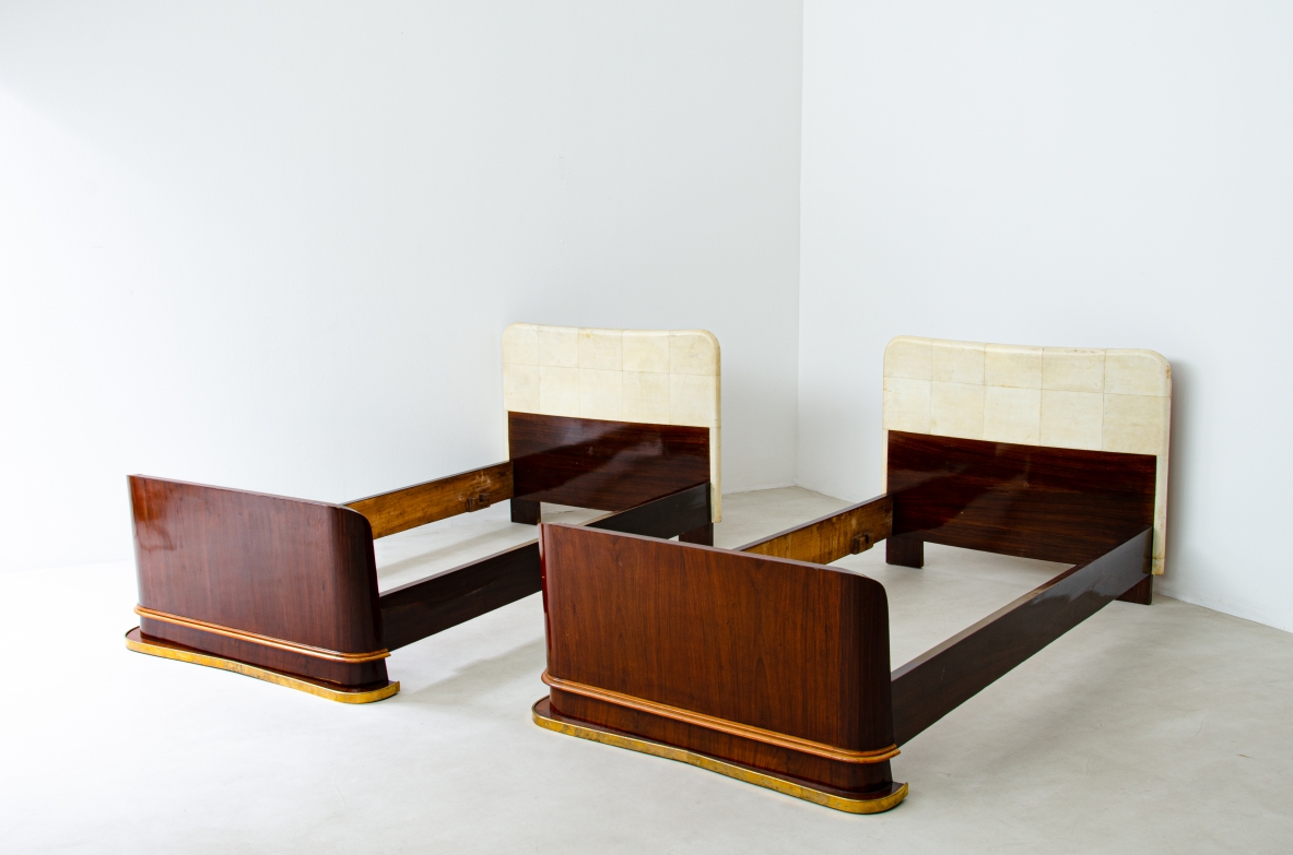 Pair of elegant rosewood beds with blond maple profiles and parchment headboard, brass details.  Italian manufacture, 1940's.