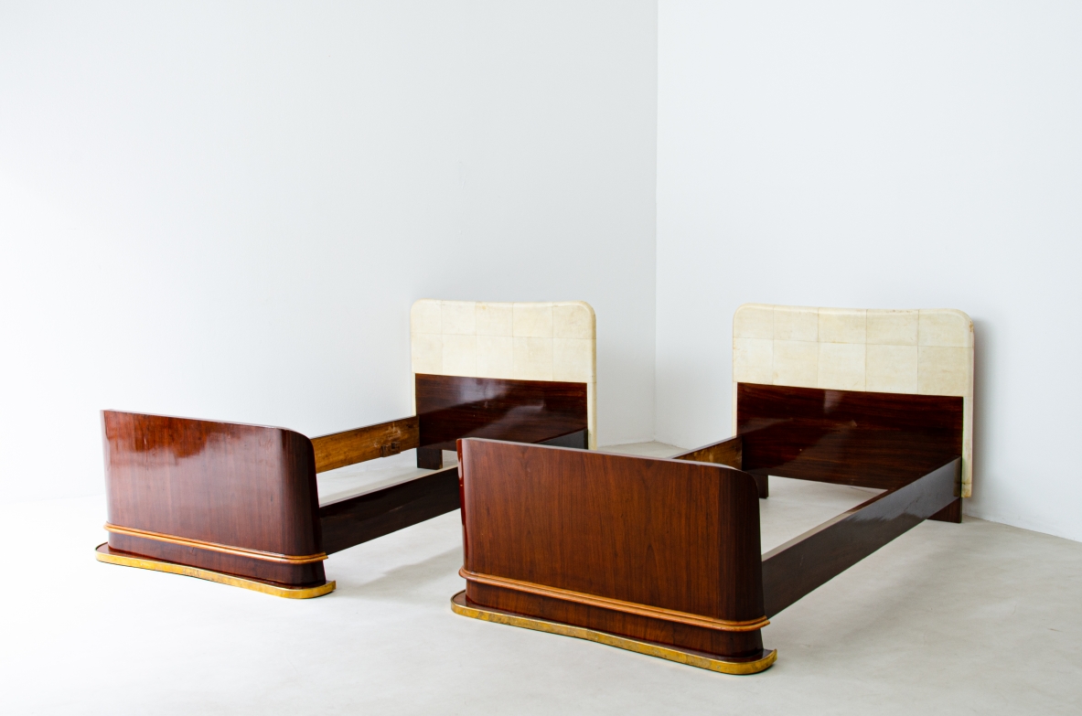 Pair of elegant rosewood beds with blond maple profiles and parchment headboard, brass details.  Italian manufacture, 1940's.