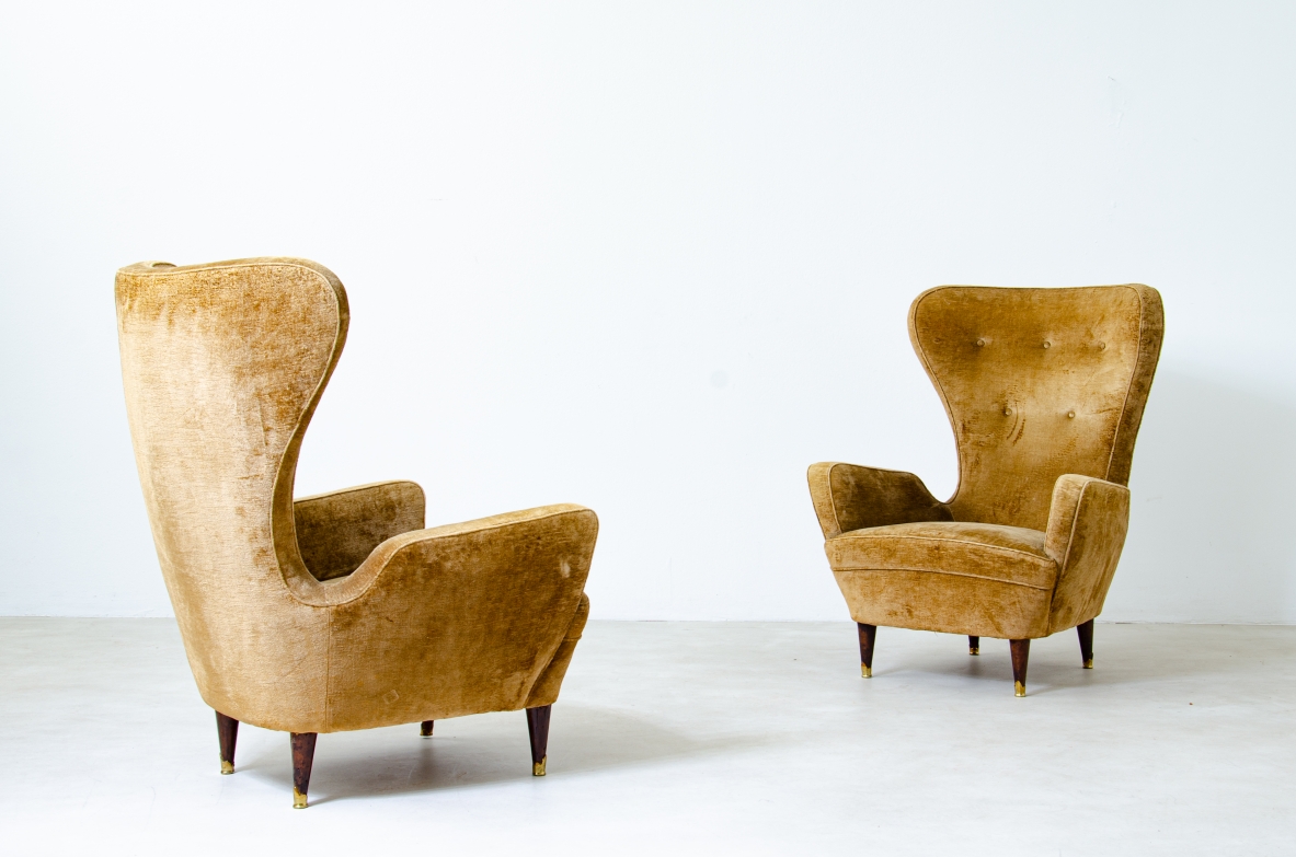 Coppia di eleganti poltrone in legno imbottito con schienale alto. Manifattura italiana, 1950ca.