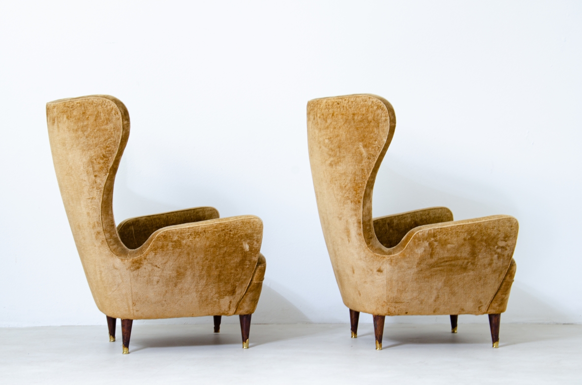 Coppia di eleganti poltrone in legno imbottito con schienale alto. Manifattura italiana, 1950ca.