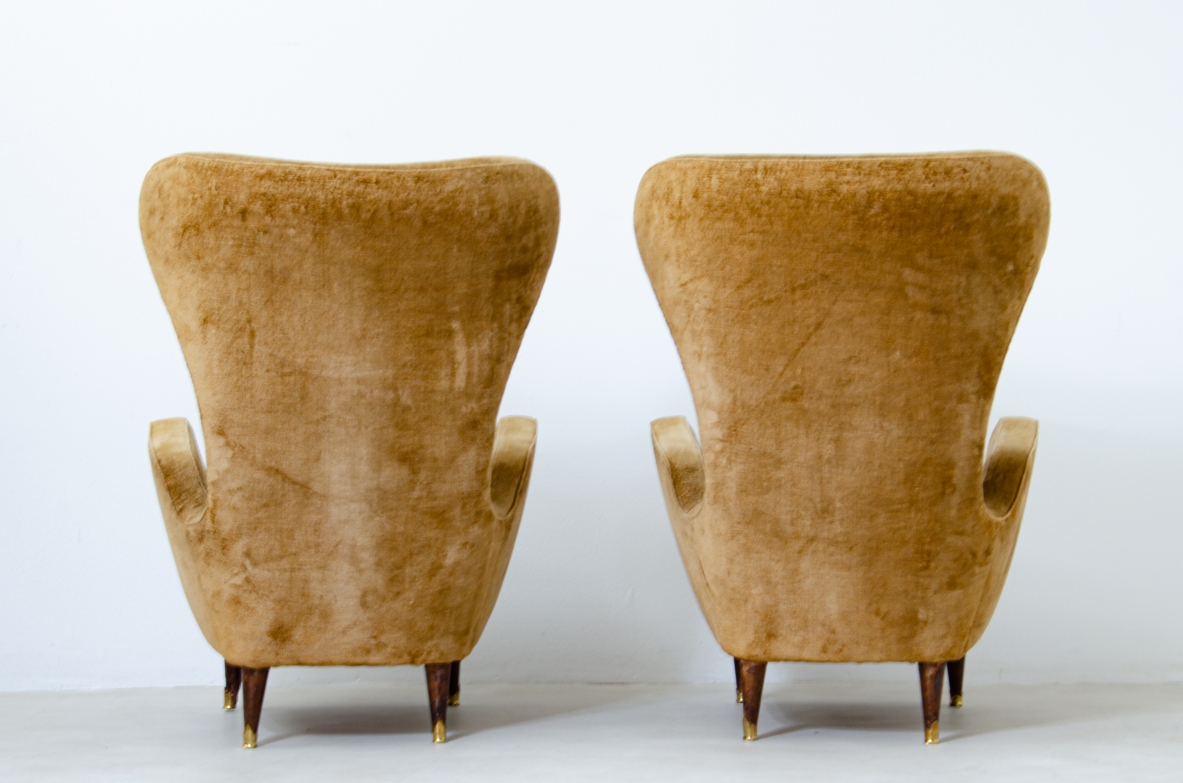 Coppia di eleganti poltrone in legno imbottito con schienale alto. Manifattura italiana, 1950ca.