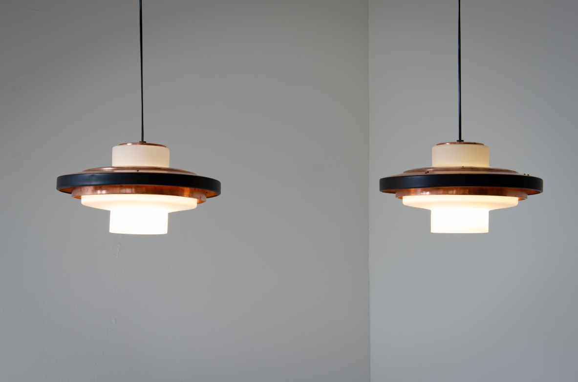 Coppia di lampadari in vetro opaline e disco in rame. Stilnovo, 1960ca. Coppia di lampadari in vetro opaline e disco in rame. Stilnovo, 1960ca.