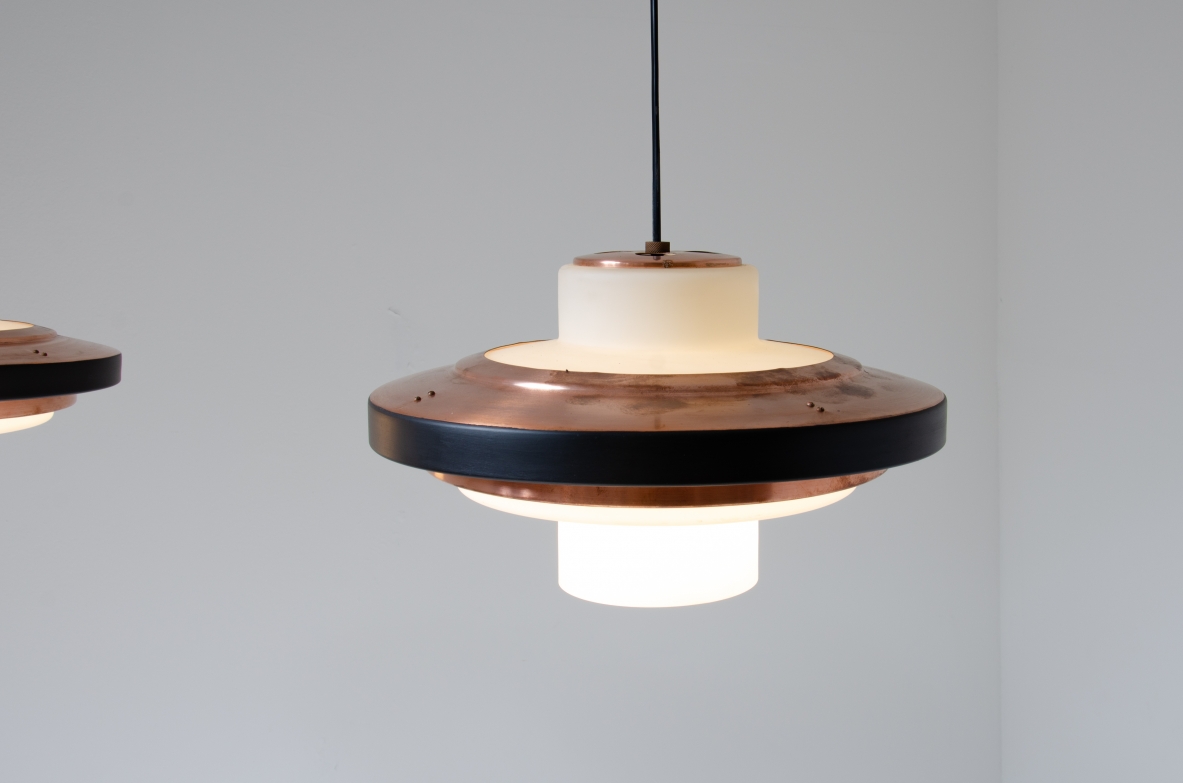 Coppia di lampadari in vetro opaline e disco in rame. Stilnovo, 1960ca. Coppia di lampadari in vetro opaline e disco in rame. Stilnovo, 1960ca.