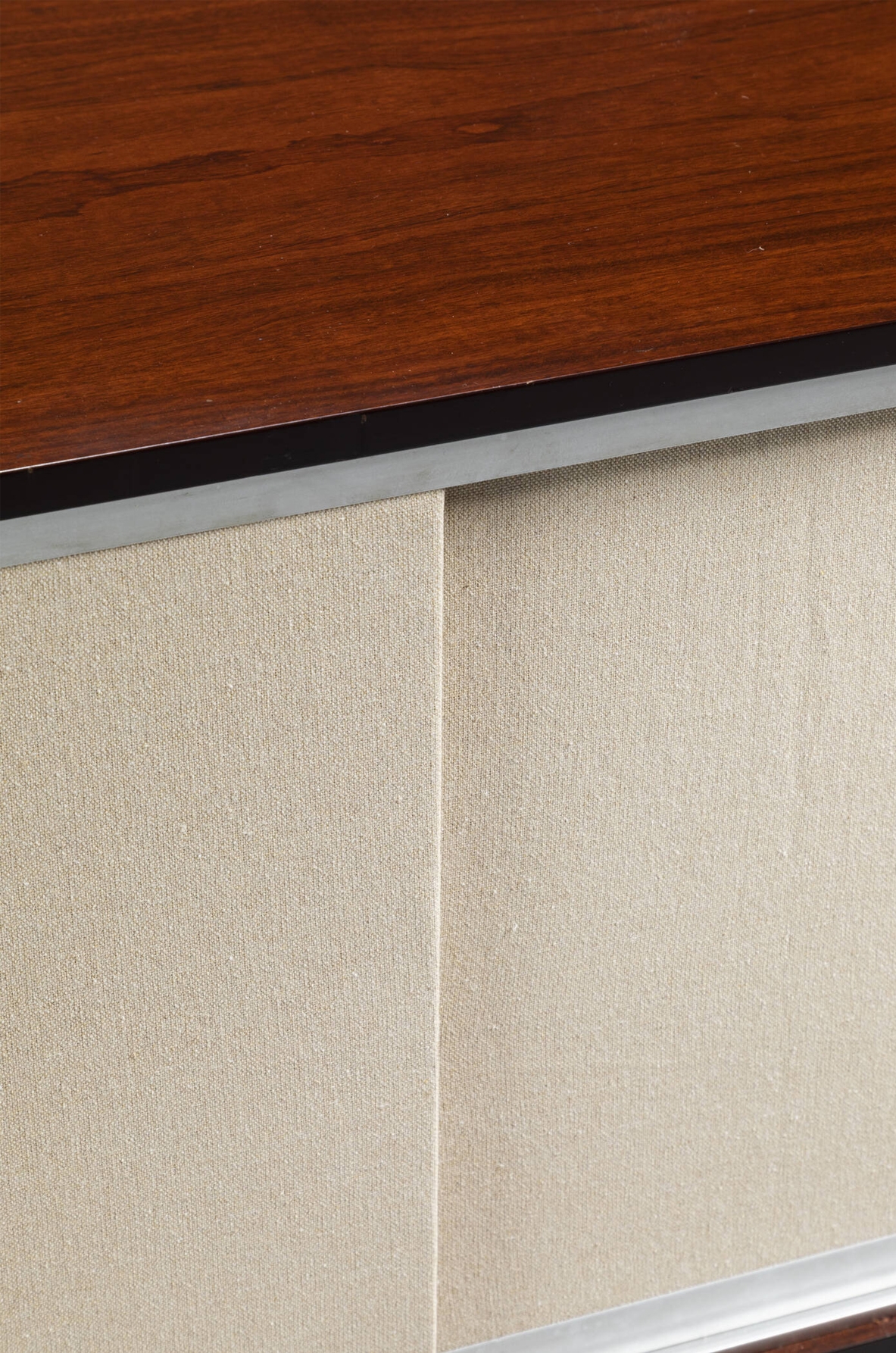 Mobile contenitore in legno con ante scorrevoli rivestite in tessuto. Manifattura italiana, 1960ca