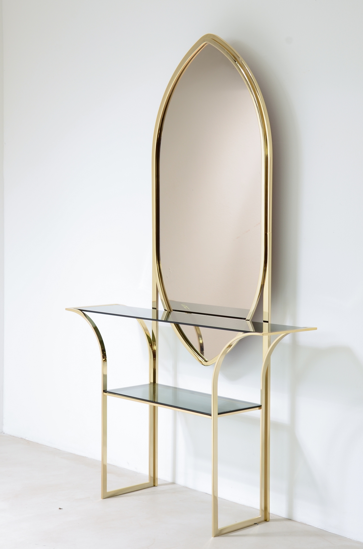 Console table in curved brass with shelves in grey blue glass and a huge mirror in burned brown color.  1970s Italian manufacture. 