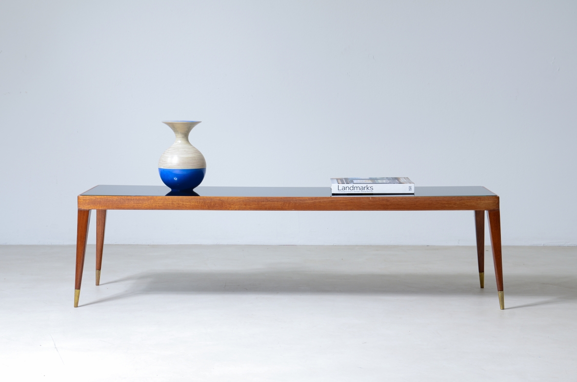 Elegante tavolo basso in mogano chiaro con puntali in ottone e piano in vetro.  Manifattura italiana, 1950ca. Elegante tavolo basso in mogano chiaro con puntali in ottone e piano in vetro.  Manifattura italiana, 1950ca.