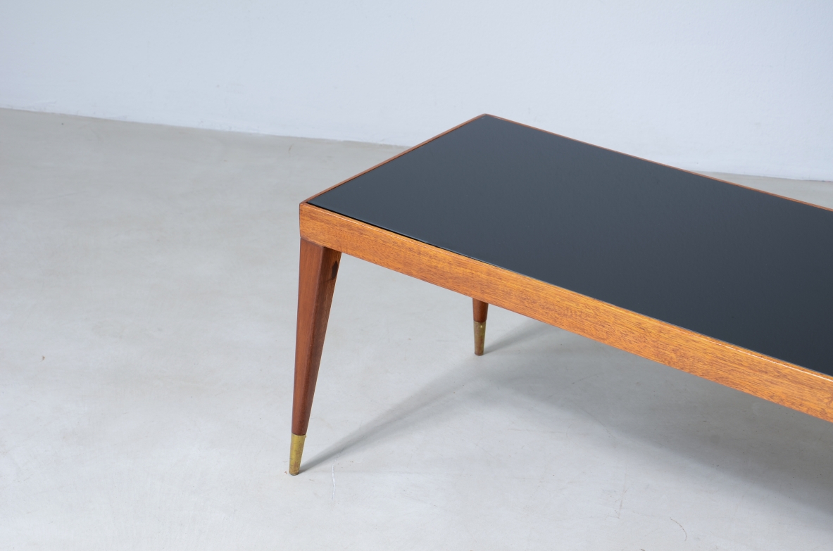 Elegante tavolo basso in mogano chiaro con puntali in ottone e piano in vetro.  Manifattura italiana, 1950ca. Elegante tavolo basso in mogano chiaro con puntali in ottone e piano in vetro.  Manifattura italiana, 1950ca.
