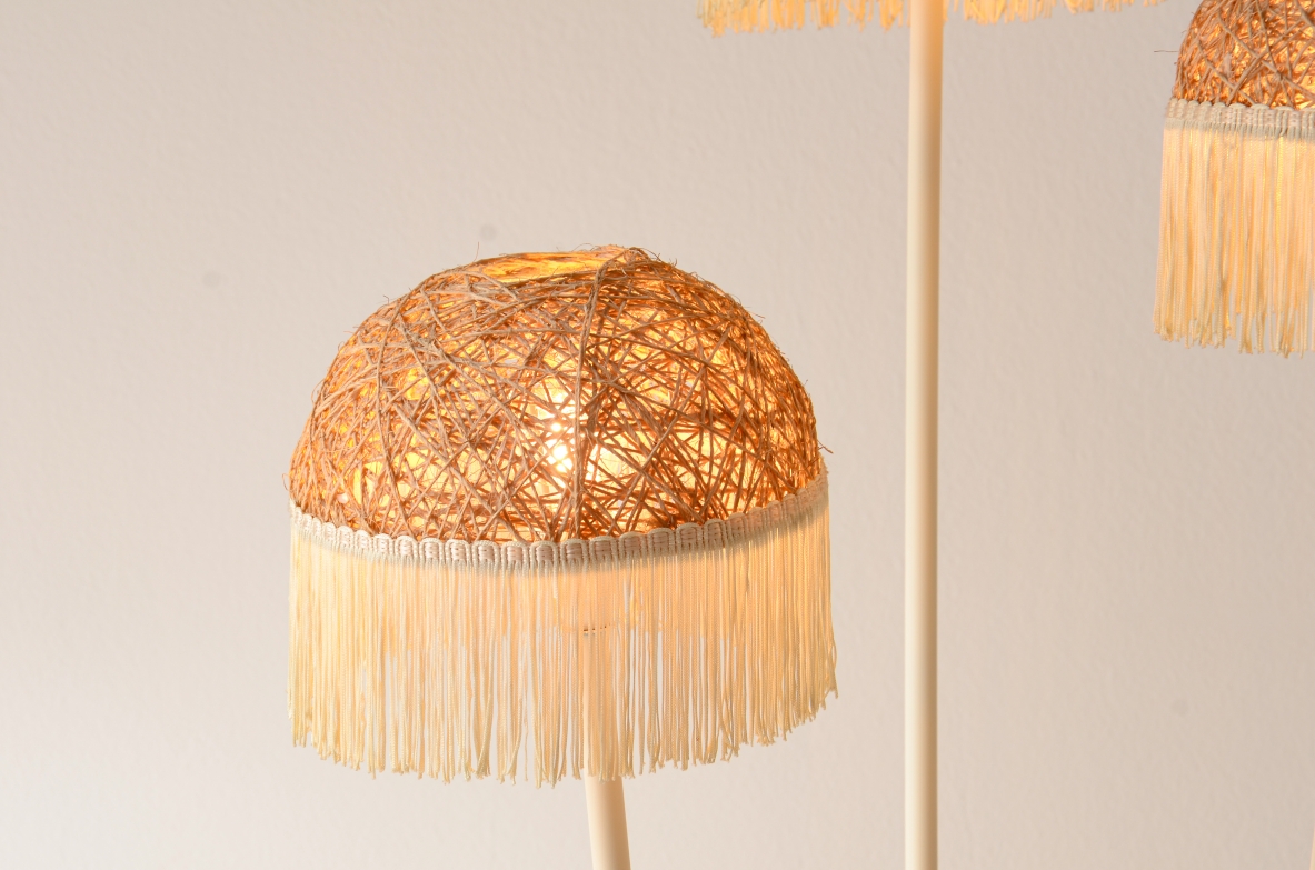 Lampada da terra a tre bracci in metallo laccato con cappelli in rattan e frange in tessuto.Manifattura italiana 1950ca. Lampada da terra a tre bracci in metallo laccato con cappelli in rattan e frange in tessuto.Manifattura italiana 1950ca.