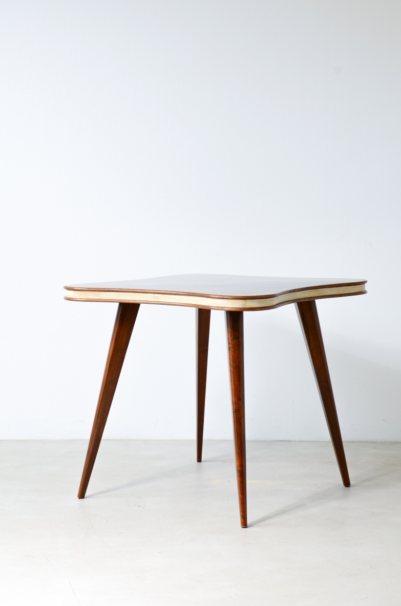 Table with four tapered legs and cloverleaf top veneered in walnut with parchment profile.  Italian manufacture, ca. 1950.