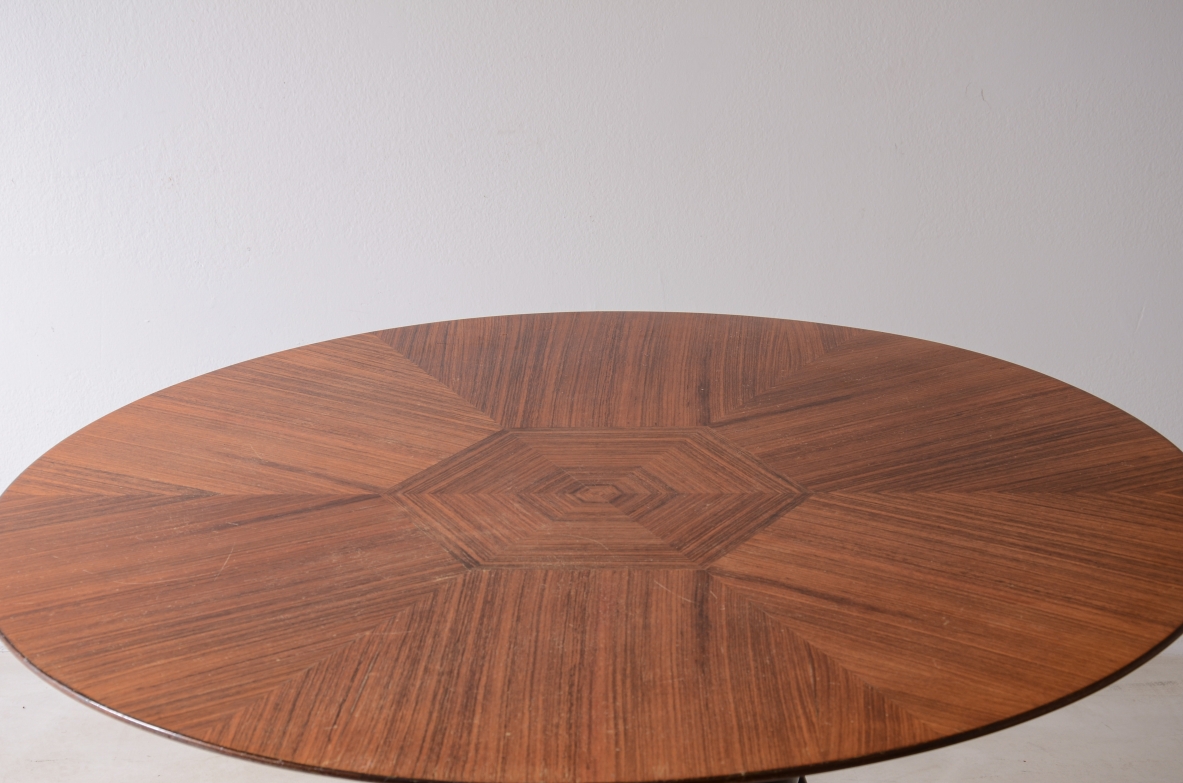 Elegant table with carved wooden base and veneered top.  Italian manufacture, ca. 1950.