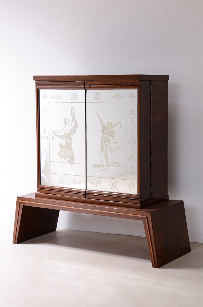 Piccolo elegante bar con fronte a due ante specchiate con figure e decori incisi.  Manifattura italiana, 1940ca.