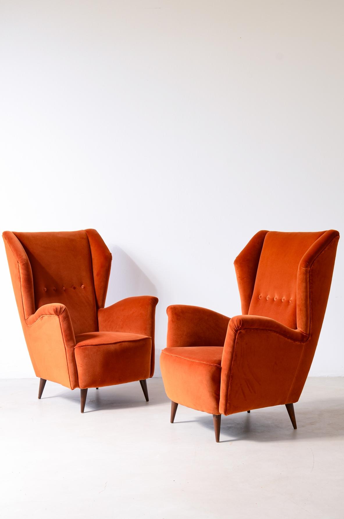 Fratelli Rizzi  Pair of armchairs with high backrest and padded velvet upholstery.