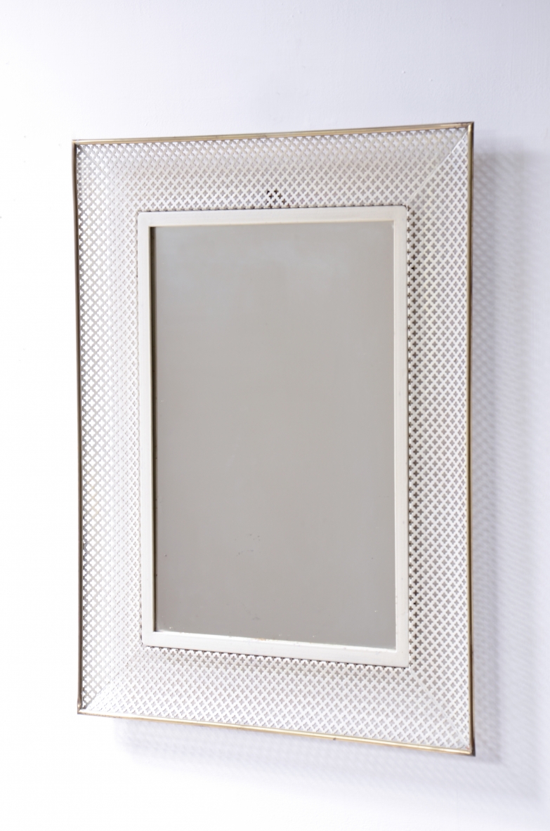 Specchiera in con cornice sagomata in rete di metallo e ottone.  Manifattura italiana, 1950.
