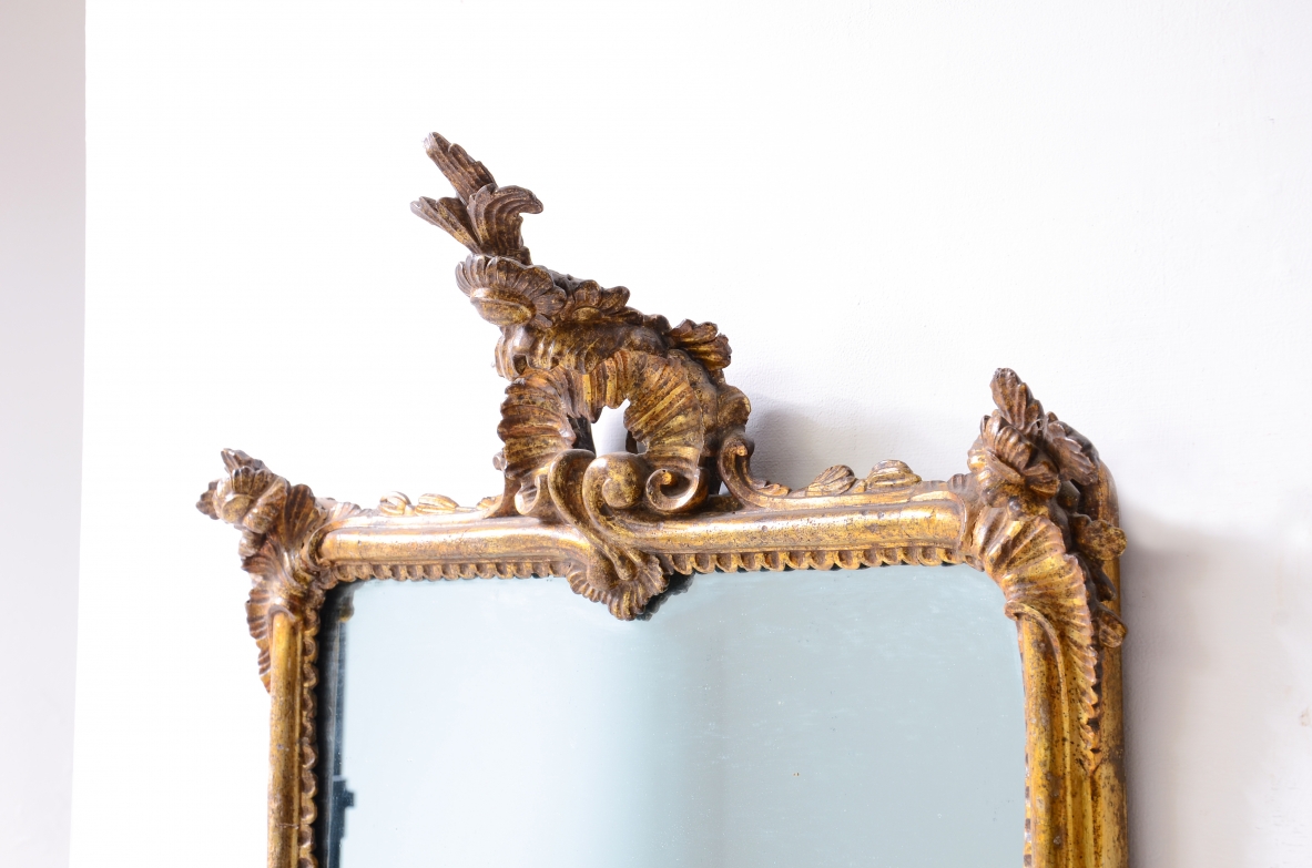 raffinata coppia di specchiere in legno intagliato e dorato a oro zecchino con specchi a mercurio.  Manifattura ligure, Italia, 1770ca.