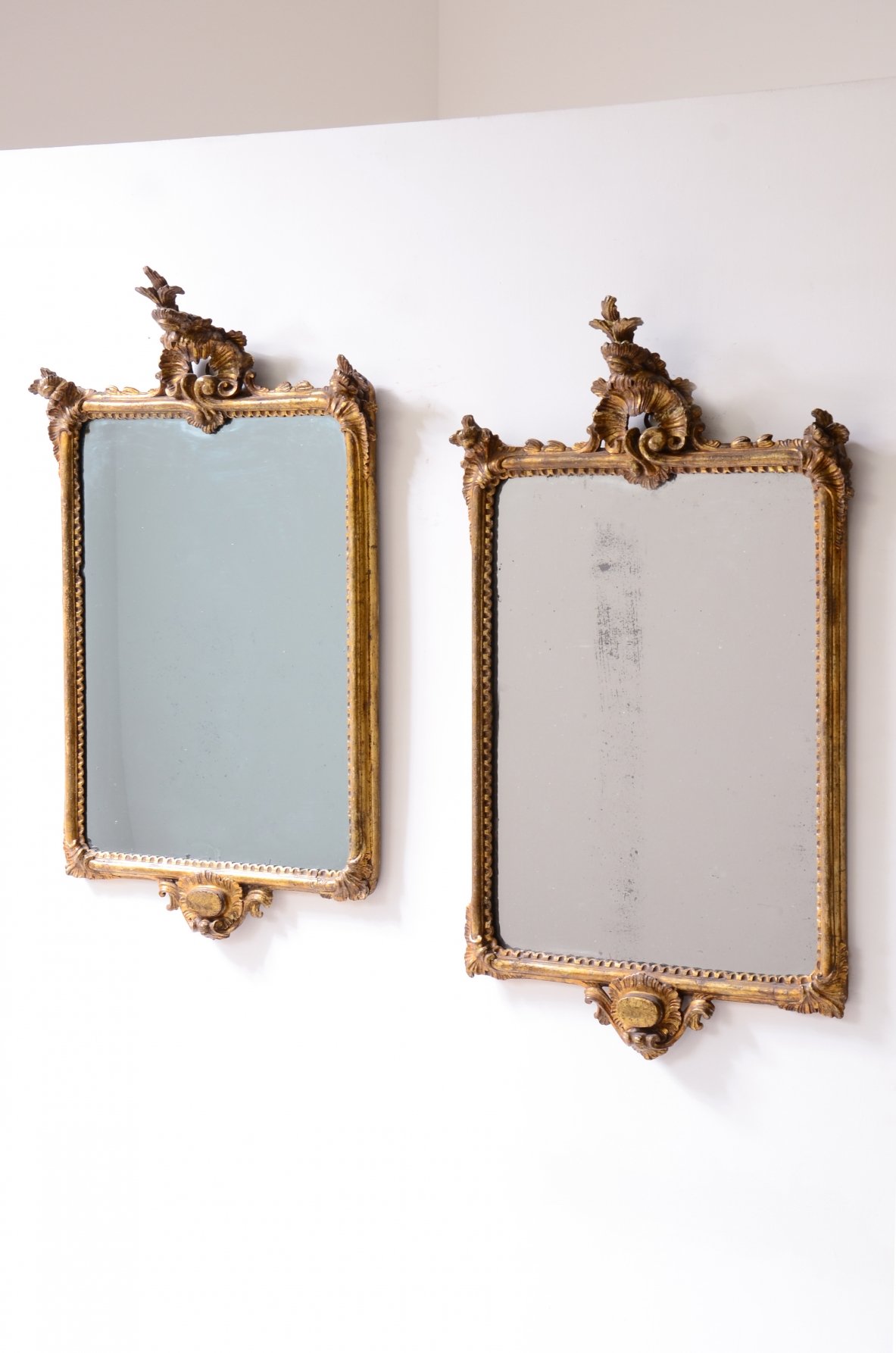 raffinata coppia di specchiere in legno intagliato e dorato a oro zecchino con specchi a mercurio.  Manifattura ligure, Italia, 1770ca.