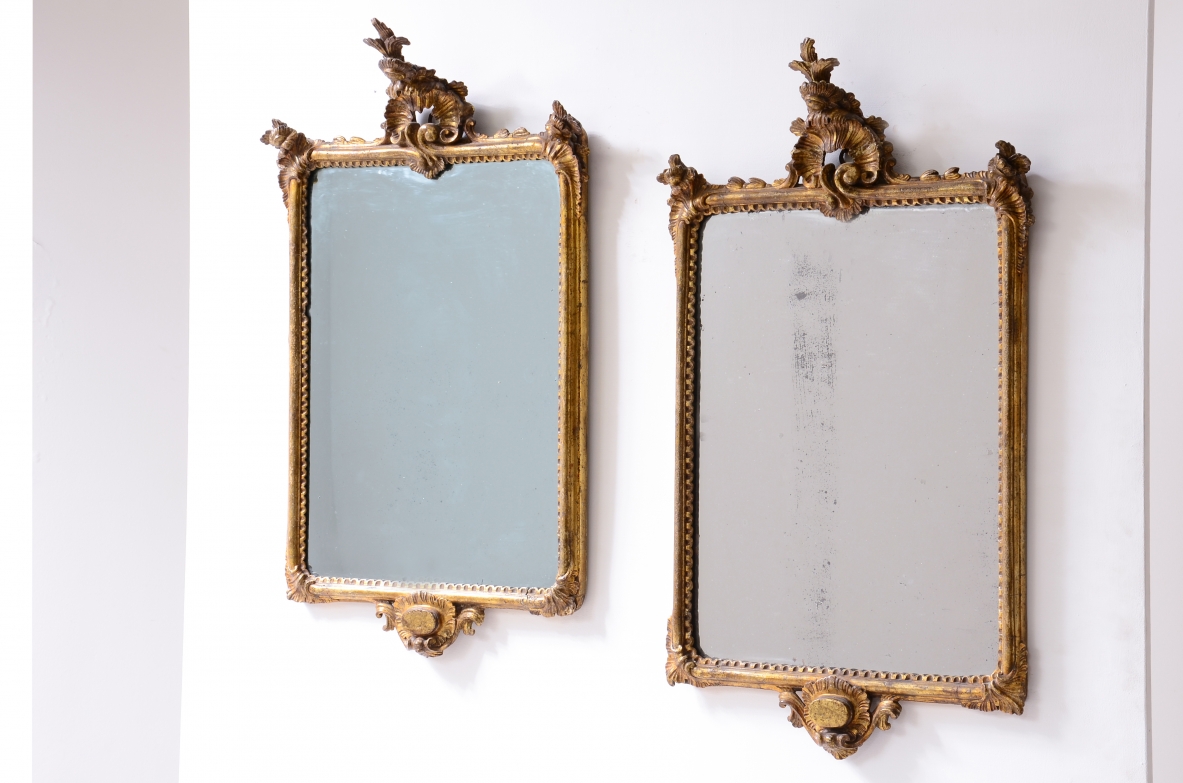raffinata coppia di specchiere in legno intagliato e dorato a oro zecchino con specchi a mercurio.  Manifattura ligure, Italia, 1770ca.