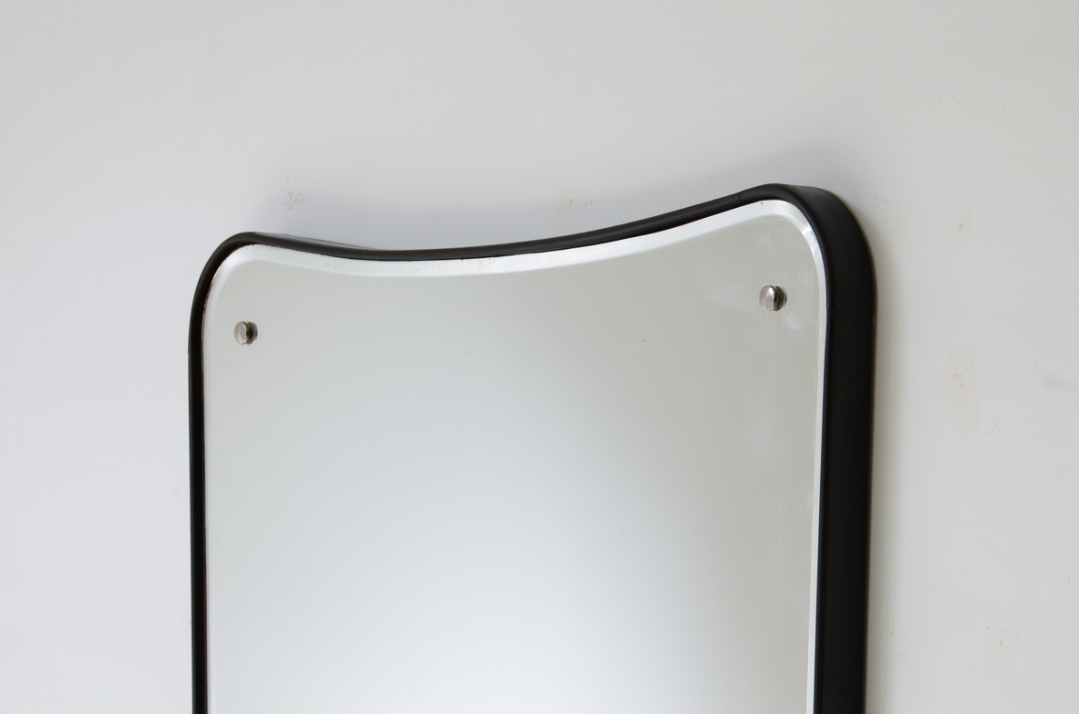 Large mirror with a shaped wooden frame. Italian manufacture, circa 1950.