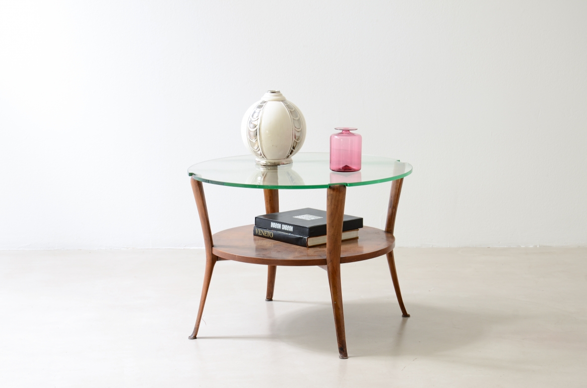 Walnut coffee table with a thick beveled glass top and four elegantly shaped legs.Italian manufacture, ca. 1950.