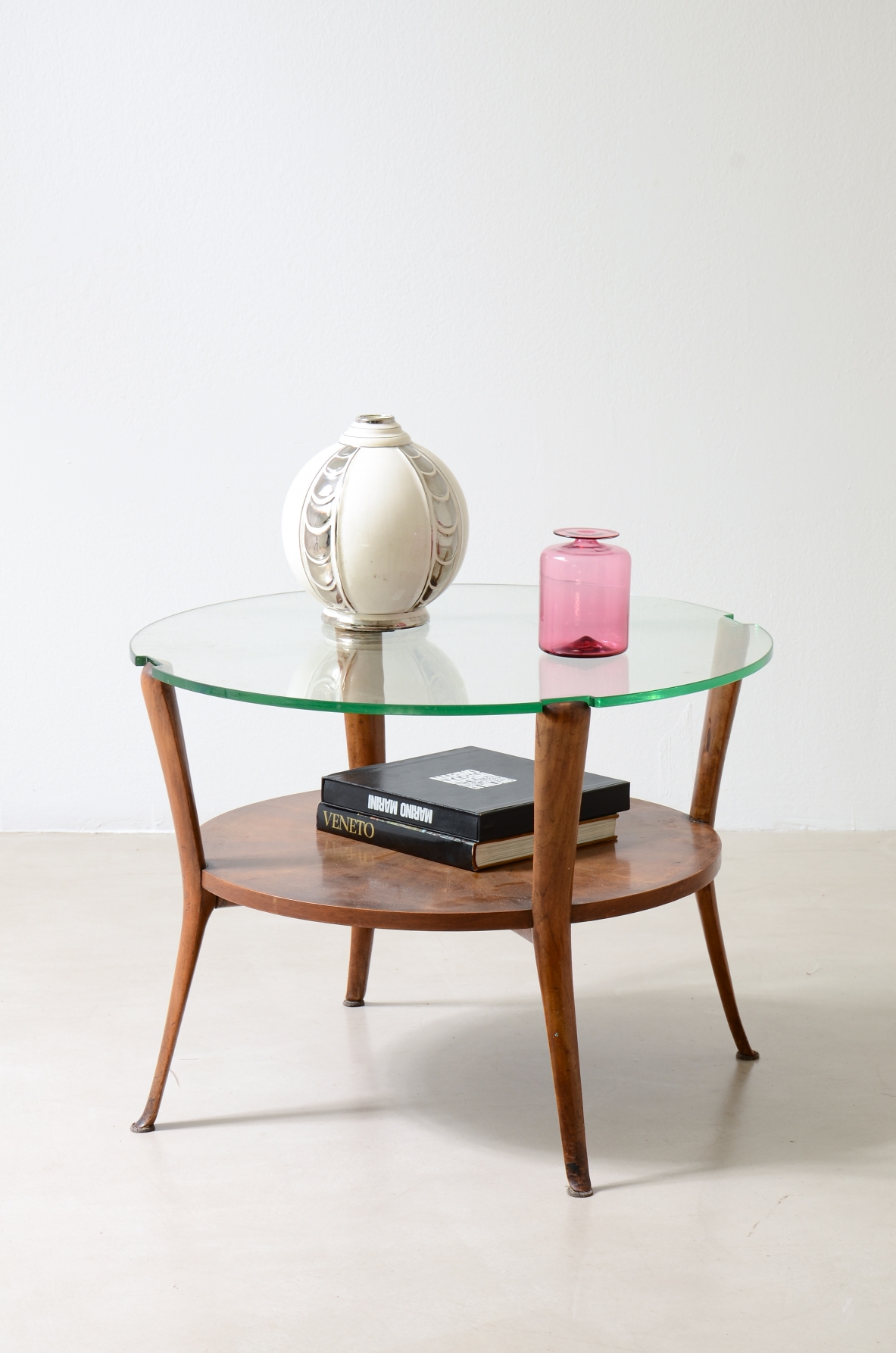 Walnut coffee table with a thick beveled glass top and four elegantly shaped legs.Italian manufacture, ca. 1950.